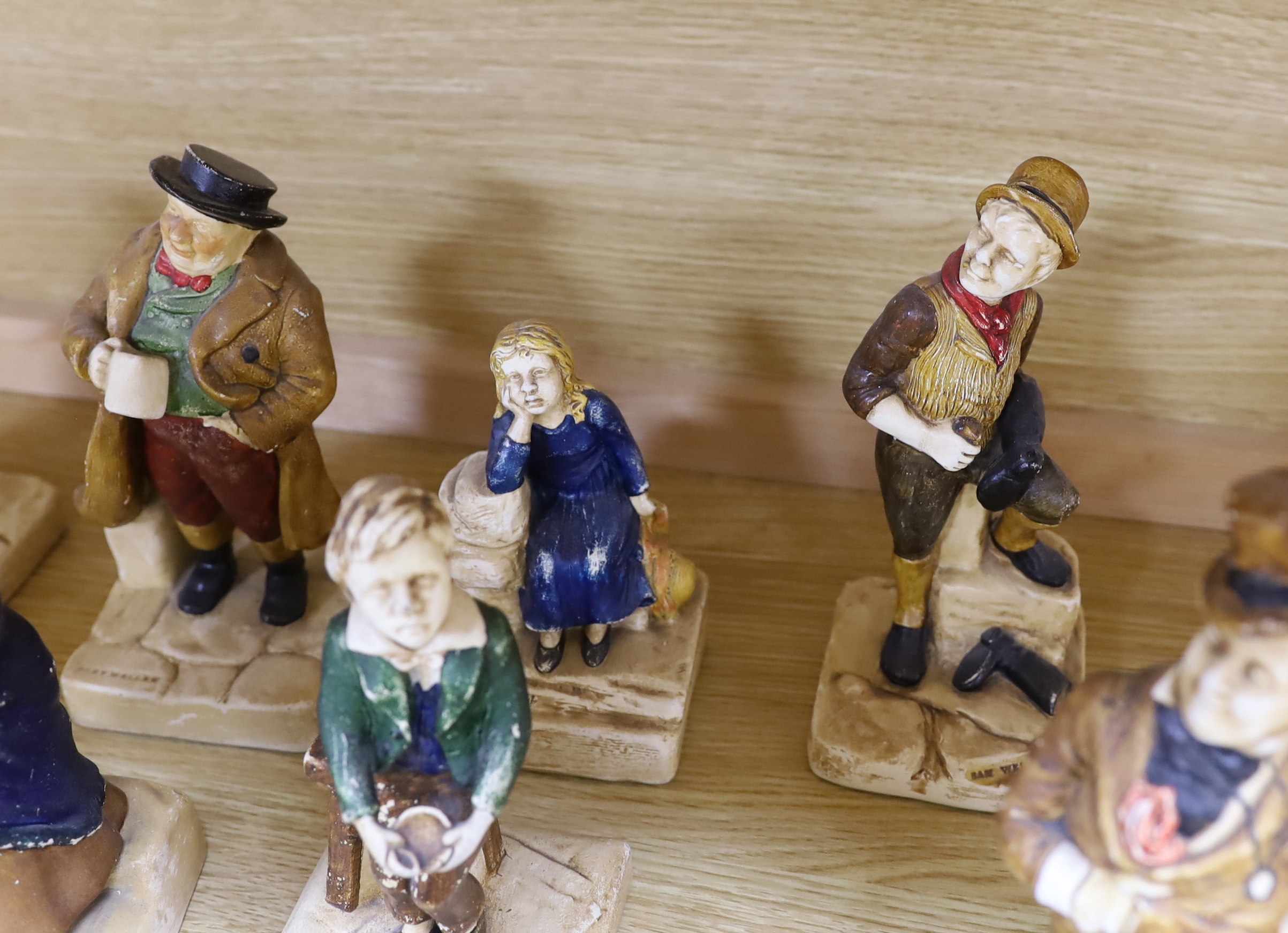 A collection of twelve Bretby cold painted pottery Dickens character figures, tallest Mr. Micawbee 25cm high